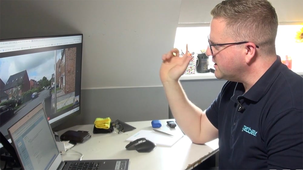 Ekspert Geobear siedzący przy biurku prowadzi wideorozmowę z klientem. Na ekranach komputera widać szczegóły rozmowy, podczas gdy specjalista omawia sytuację.